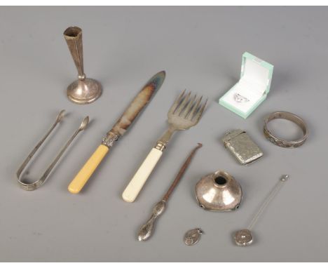 A mixed collection of sterling silver and white metal items, featuring a 1914 silver button hook, a 1901 silver ring cake kni