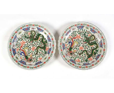 A large pair of decorative reproduction Chinese chargers, decorated in Kangxi style in famille verte enamels with dragons and
