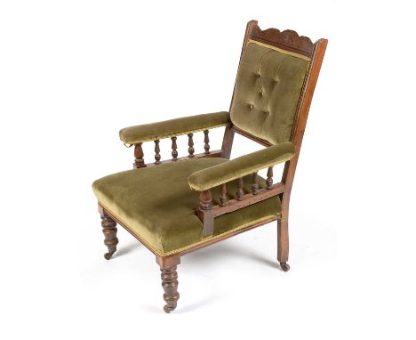 A Victorian mahogany easy armchair, with arched top rail, deep button back and padded arms on turned supports above a sprung 