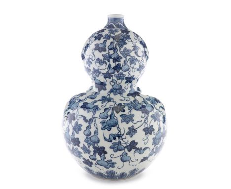 A Chinese blue and white double gourd-shaped vase, decorated with vines, gourds and bats, Yongzheng seal mark, 33cms.