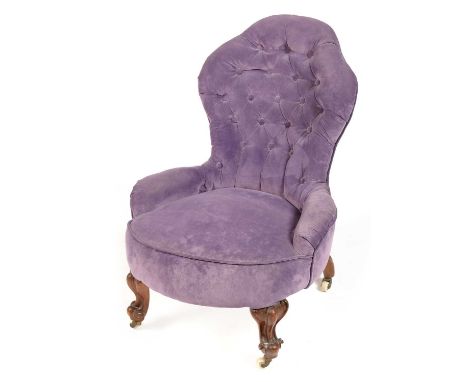 A Victorian mahogany nursing chair, upholstered in lilac fabric, the shaped deep button back above a padded seat and raised o