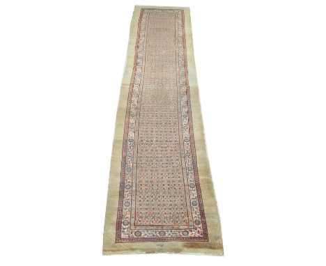 An antique Caucasian runner, with floral panels flanked by foliate border and a mushroom-coloured surround, signed, 461 x 107