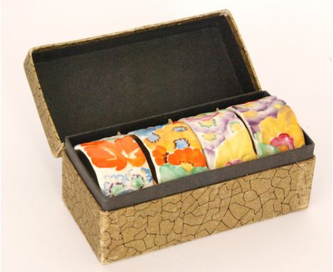 Clarice Cliff - My Garden - A boxed set of four napkin rings relief moulded with flowers and foliage with enamel decoration, 