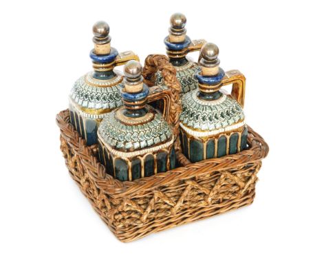 Doulton Lambeth - A set of four stoneware spirit flasks each of shouldered square section with collar necks and cork mounted 