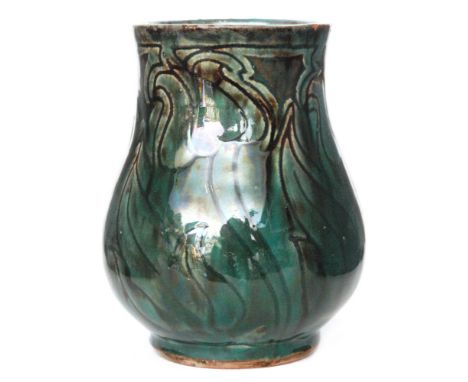 Della Robbia - A small early 20th Century vase decorated with incised stylised wrythen tulips, the whole glazed in a mottled 