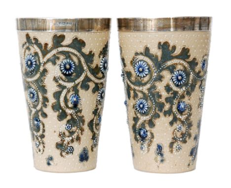 George Tinworth - Doulton Lambeth - A pair of silver collared beakers, the tapering cylindrical bodies decorated with a scrol