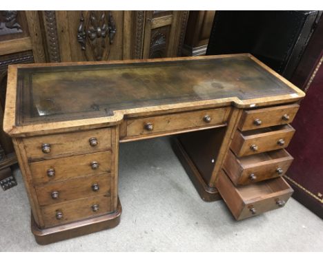 A leather topped kneehole desk with flight of four drawers to each side on caster feet..Approx 51x1.32mx73cm