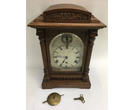 An oak cased mantle clock with metal dial and Kienzle movement