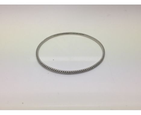 An 18ct white gold diamond line bangle of contemporary design.