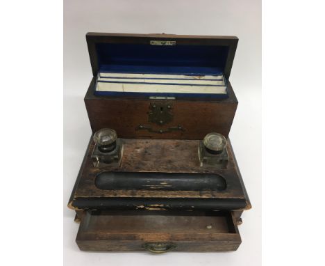 An oak desk stationary box inset with inkwell pen tray.Approx 30cm long