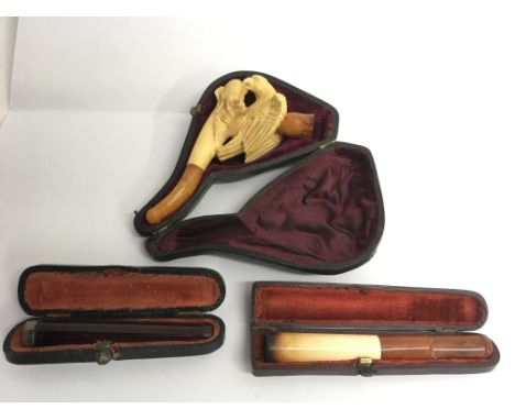 A cased Meersham pipe, the bowl formed as an eagle with amber mouthpiece plus two cheroot holders
