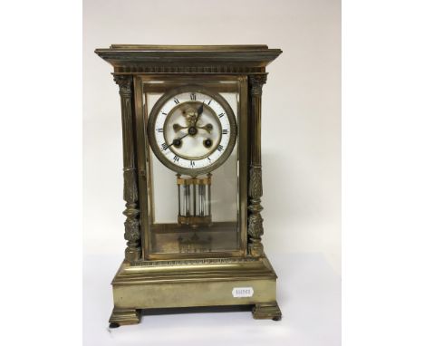 A Quality late 19th Century French Four glass brass clock, with stylised pillars. With an enamel dial and visible escapement.