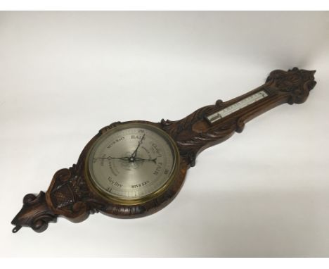 A Victorian carved oak barometer made by Moses Ash of Birmingham.