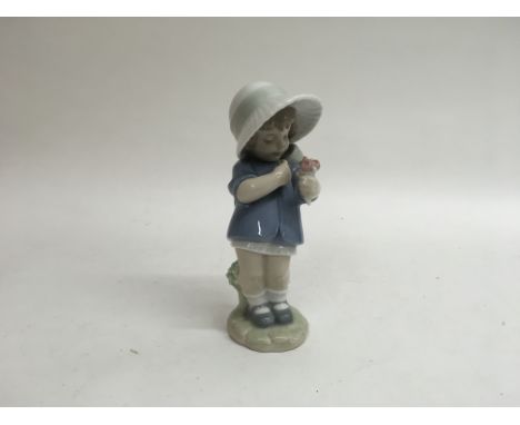 A Nao figure of a little girl with a bonnet and flowers with original box. Measures approximately 22cm high.