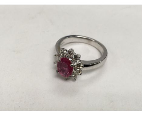 An 18ct white gold ring set with a central ruby surrounded by ten diamonds, approx 6.55g and approx size M-N.