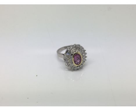 A 14ct white gold diamond cluster ring with a pink sapphire. Ring size O. Sapphire is 2.10 carat and the diamond is 1.15 cara