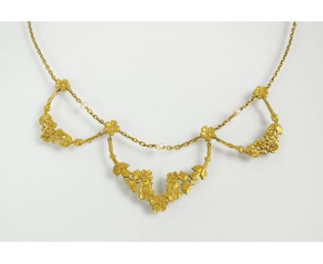 An early 20th century yellow metal and seed pearl necklace, designed as three graduated floral garlands mounted to seed pearl