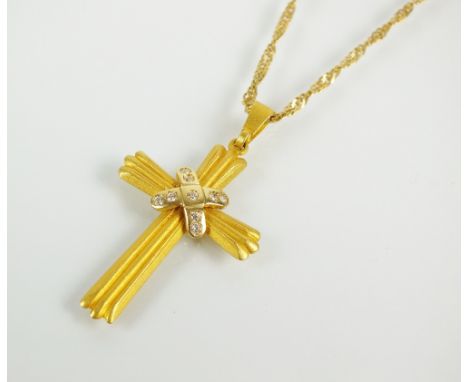 A diamond set crucifix pendant, the yellow metal reeded crucifix set to the centre with nine brilliant cut diamonds, the reve