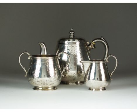 A three piece Bachelors silver tea service, T.W., London 1876, each piece with engraved tendril vine decoration and crest, co