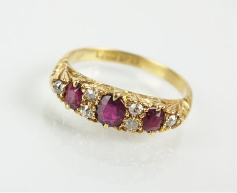 An 18ct gold nine stone ruby and diamond ring, designed as three oval mixed cut rubies interspersed with six diamonds, claw s