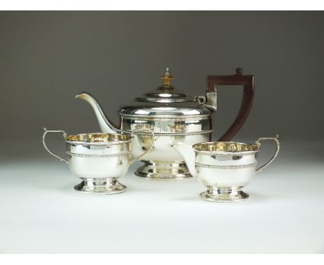 A three piece silver tea service, Selfridge & Co Ltd, Birmingham 1933, each piece of circular form with beaded band to the wa
