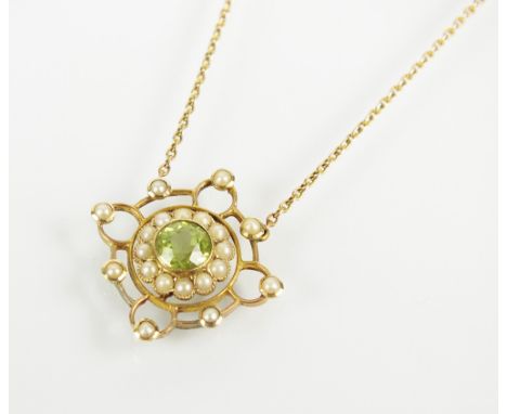 An early 20th century peridot and seed pearl pendant, designed as a central round mixed cut peridot milligrain set within a b