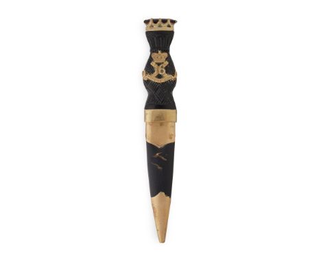 the carved handle set with brass regimental badge and motto, the pommel with claw set paste, brass mounted scabbard and scall