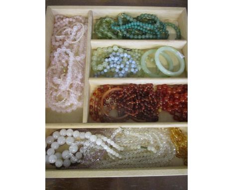 A quantity of oriental hardstone jewellery to include jade bangles, rose quartz and Chinese cornelian necklaces 