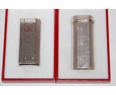 A Must de Cartier pocket cigarette lighter in fitted red leather box with paperwork together with one other similar example (