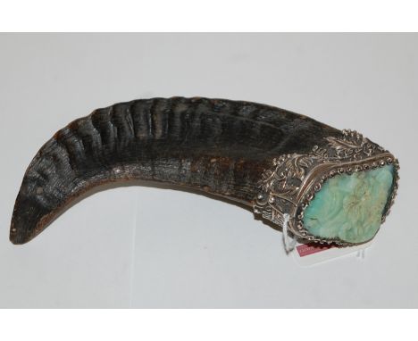 A rams horn snuff-mull, the hinged cover inset with a jade panel, carved in relief with a mask of Pan, the white metal mounts