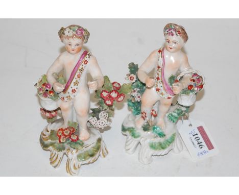 A pair of Bow porcelain figures of putti, each holding a basket of flowers, circa 1760, each wearing a sash and standing agai