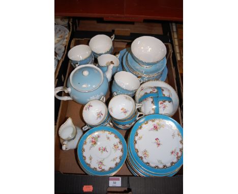 An early 20th century part tea service by Coalport, having painted floral decoration on a turquoise ground, heightened in gil