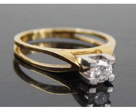 A contemporary 18ct gold diamond solitaire ring, the four-claw set brilliant weighing approx 0.32 carats, on bifurcated shank