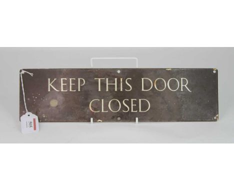 An enamel on metal sign inscribed 'Keep this door closed', 10 x 38cm 