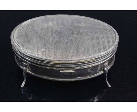 A large George V silver trinket box of oval form, the hinged engine turned cover with gilt washed underside opening to a blue