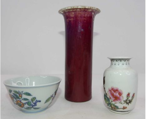 A Chinese sang-de-boeuf sleeve vase, h.15cm; together with a Chinese enamel decorated vase; and a Chinese polychrome porcelai