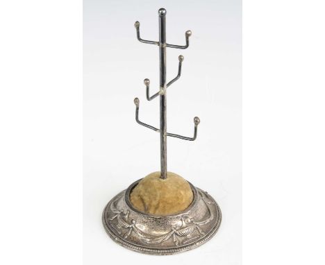 A George V silver six branch ring tree, the weighted concave circular foot relief decorated with Grecian urns and swags, make