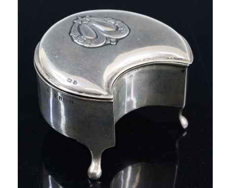 An Edwardian silver trinket box of crescent shape, the hinged cover embossed with swags opening to a blue felt lined interior