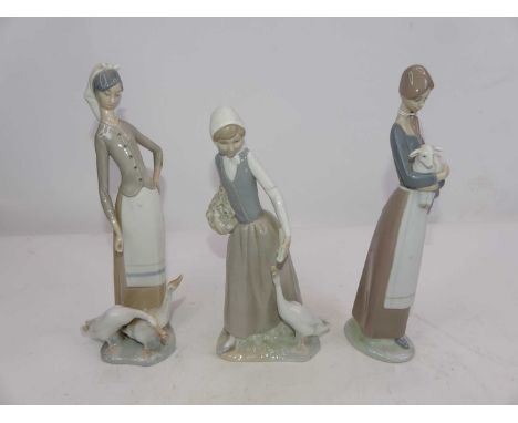 Two Lladro and one Nao porcelain figures of young ladies, largest h.28cm 
