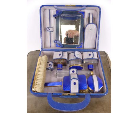 A 20th century blue guilloche enamel decorated travel dressing table set, housed in a blue carry case, together with a matchi