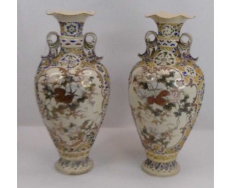 A pair of Japanese satsuma vases, each of twin handled baluster form, underglaze and enamel decorated with figures within car