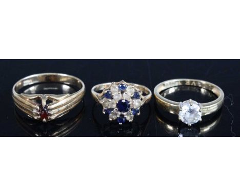 Three 9ct yellow gold rings, comprising a 6mm cubic zirconia solitaire, size N½; a multi-sapphire circular cluster ring with 