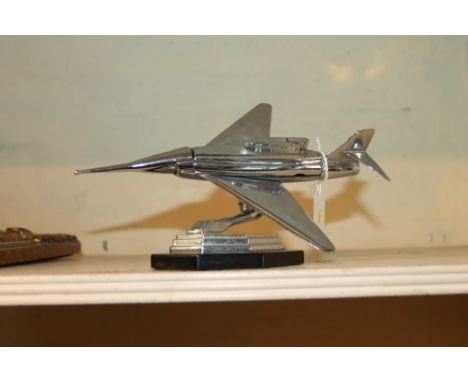 Novelty table cigarette lighter in the form of a chromium plated jet fighter, on a black octagonal stand