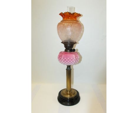 Victorian oil lamp with Duplex burner and pink and white glass reservoir, on a fluted brass column and black ceramic base, cl