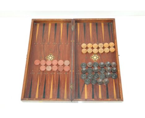 Rosewood folding backgammon and chessboard with inlaid ivory boxwood and ebony decoration and a quantity of turned playing pi