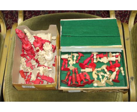 Two boxes containing a quantity of plain and red stained ivory chess pieces from two different sets (2)