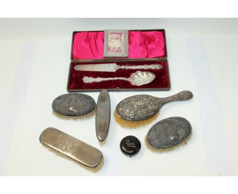 Five silver mounted dressing table brushes, a small silver photograph frame, tortoiseshell box with silver mount and a silver