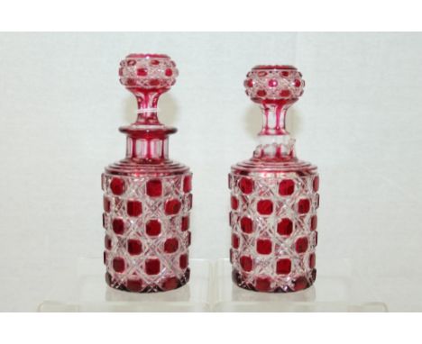Pair ruby cut glass decanters with stoppers   CONDITION REPORT  One decanter has neck completely broken off and a few chips a