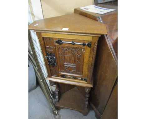 An early 20th century Gothic revival carved oak corner cabinet with a door over a shelf, 43" h x 17 1/2" w 