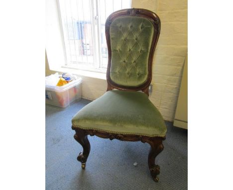A Victorian rosewood upholstered chair with button back on carved, French cabriole front legs, scrolled end feet and brass ca